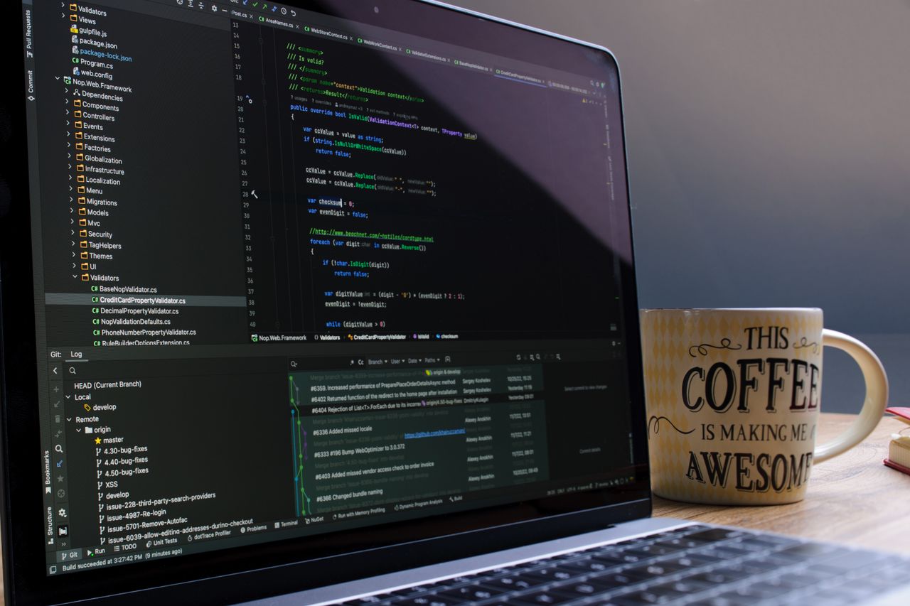 Mastering the First Impression: Your intriguing post title goes here Close-up of laptop with coding software and a motivational coffee mug on a desk.